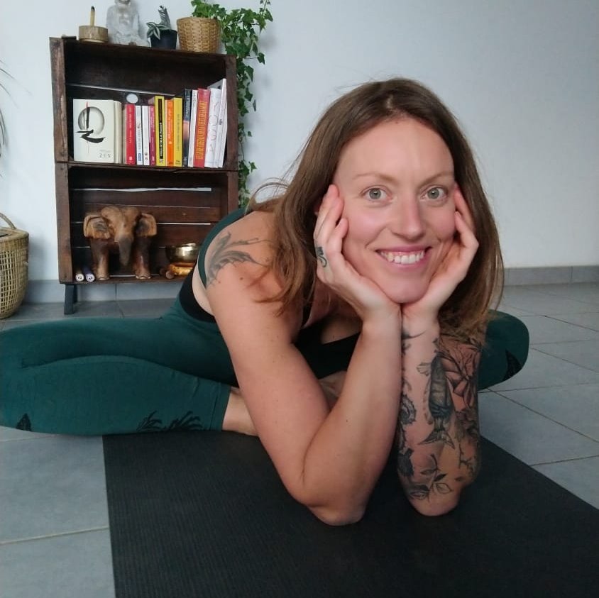 Anne-Sophie Ring, souriante, allongée sur son tapis de yoga